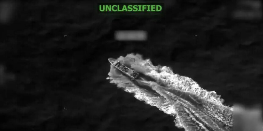 Night-vision style image of a fast-moving vessel carving a wake through dark water, with 'UNCLASSIFIED' in green text at the top.
