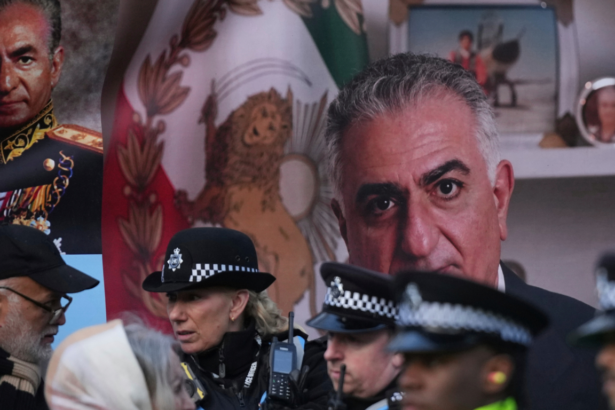Police officers in uniform chatting in front of a large portrait and a Mexican flag backdrop.
